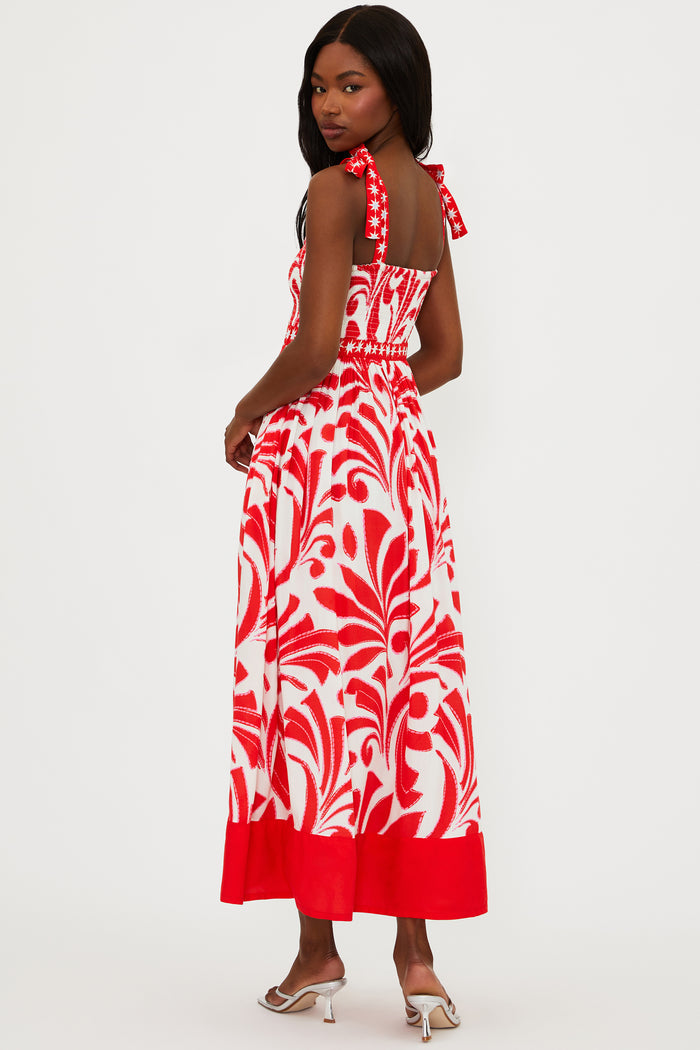 Woman wearing a red and white patterned dress on a white background
