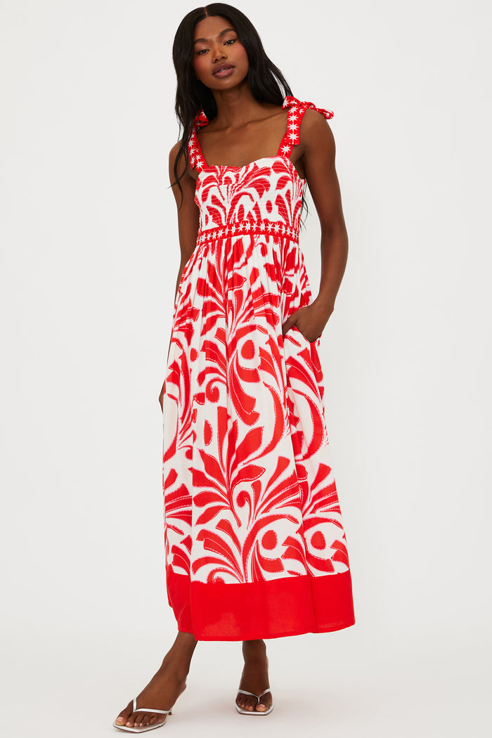Woman wearing a red and white patterned dress on a white background