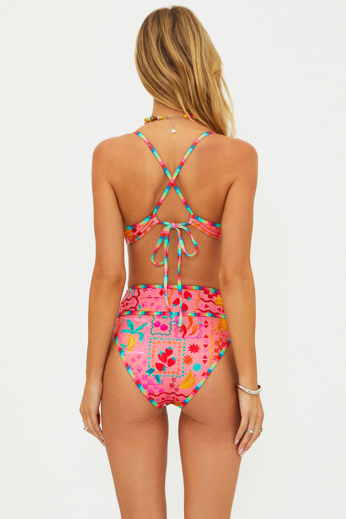Woman wearing a colorful bikini with a pink floral pattern on a white background
