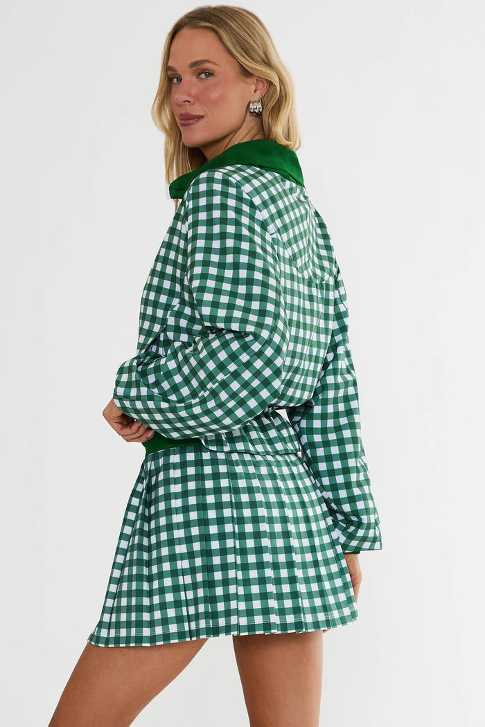 Woman wearing a green and white checkered dress on a plain background