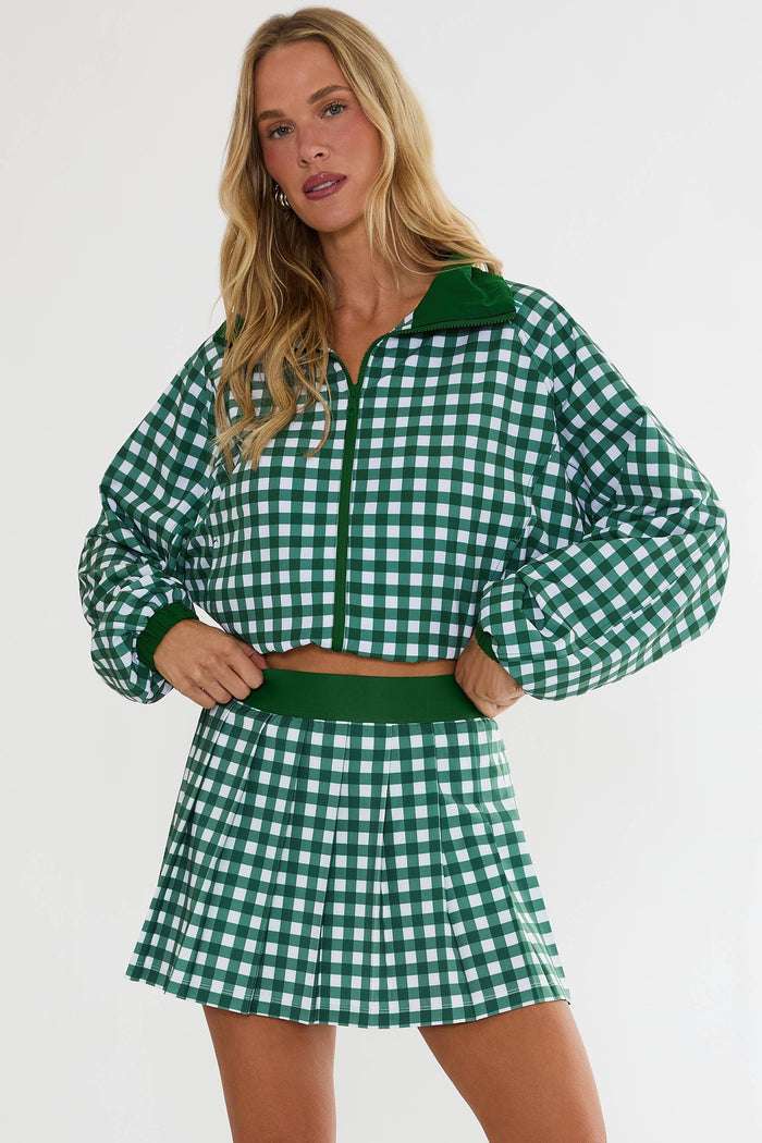 Woman wearing a green and white checkered outfit on a plain background