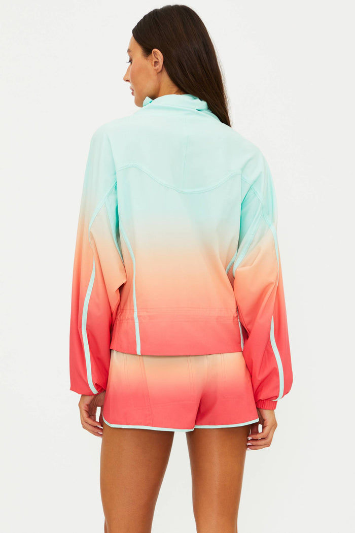 Woman wearing a colorful gradient jacket and shorts on a white background