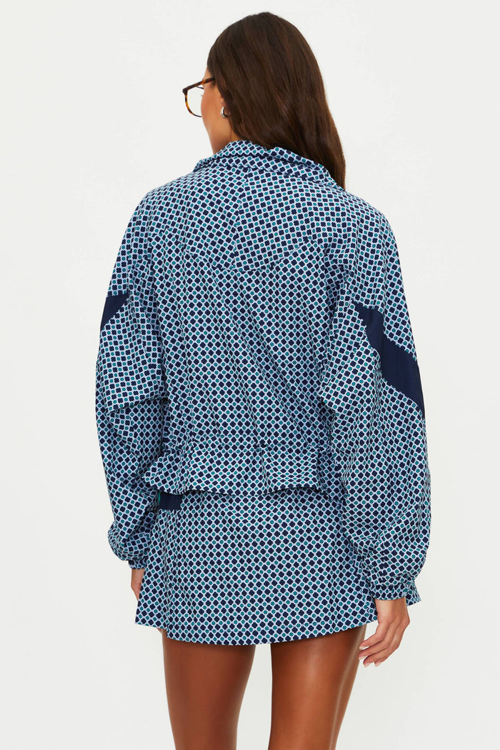 Woman wearing a blue patterned outfit on a plain background