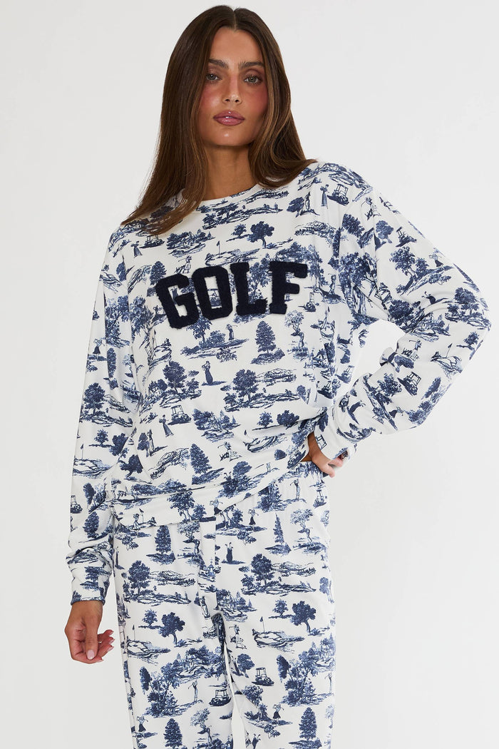 Person wearing a long-sleeve shirt with 'GOLF' text and a patterned design on a white background