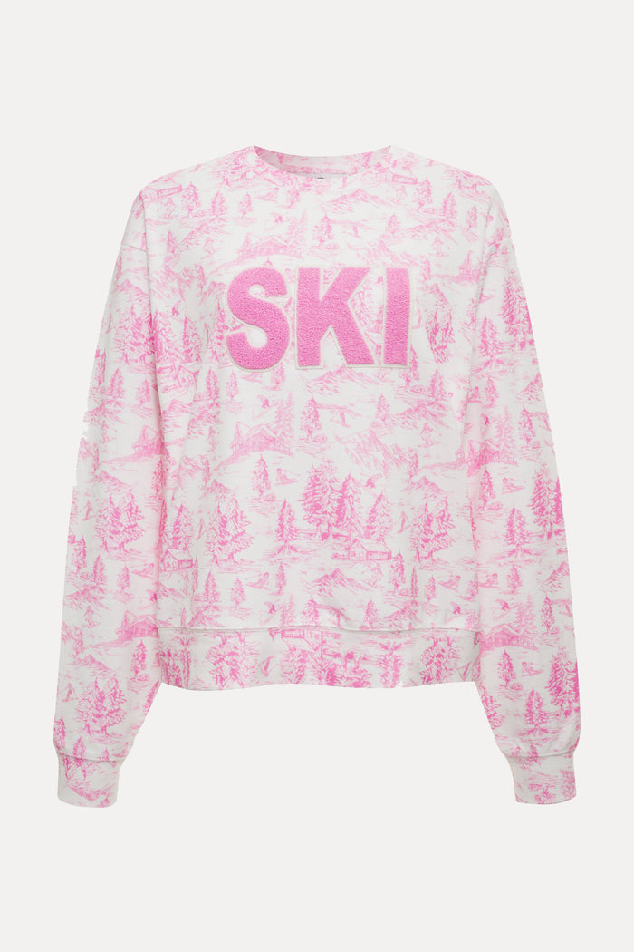 Woman wearing a pink and white tie-dye 'SKI' sweatshirt on a white background