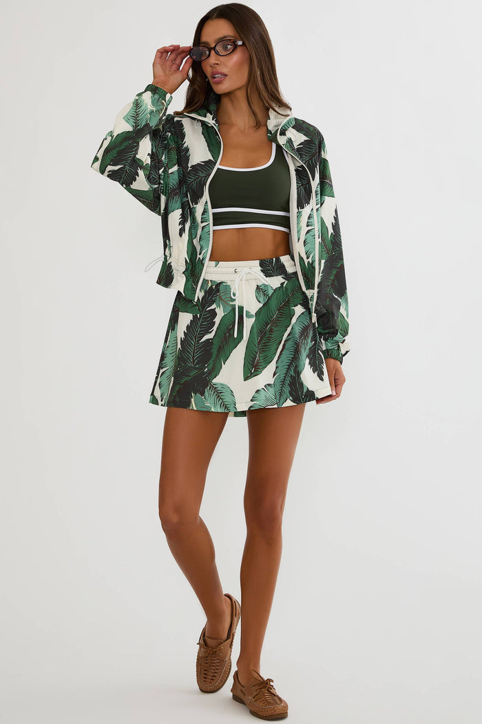 Woman wearing a green and white leaf-patterned outfit on a white background