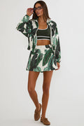 Woman wearing a green and white leaf-patterned outfit on a white background
