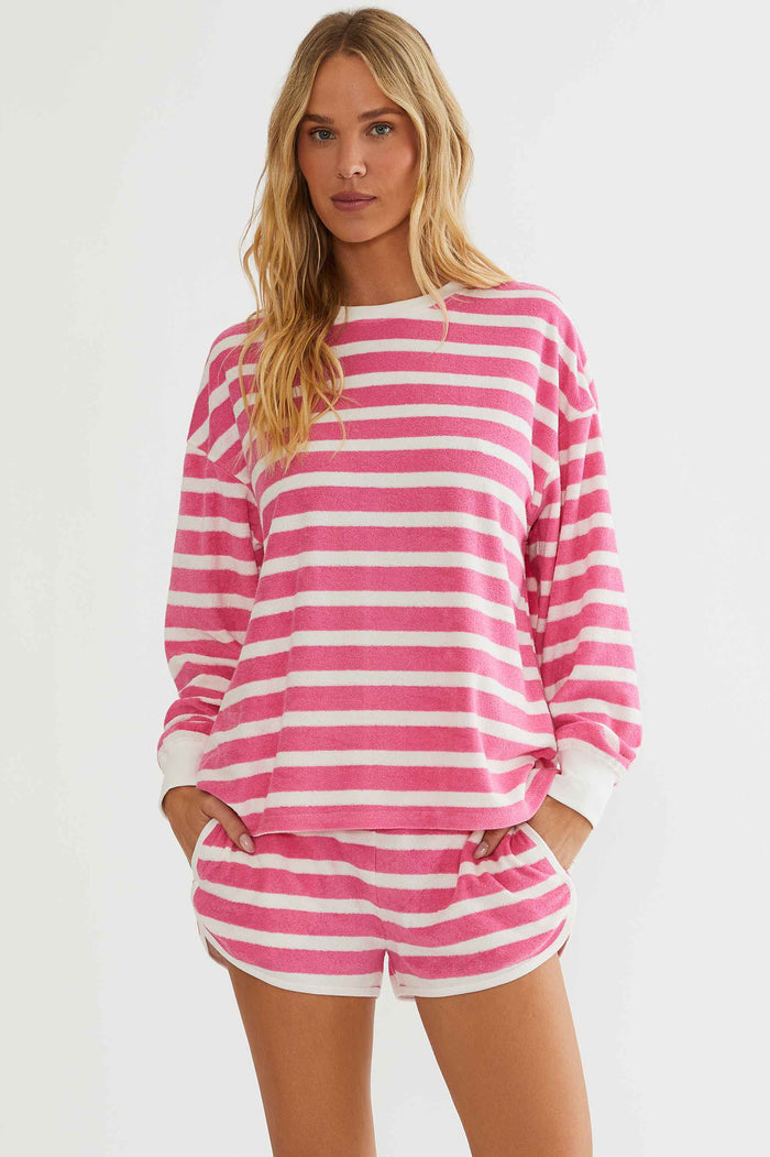 Woman wearing a pink and white striped outfit on a plain background