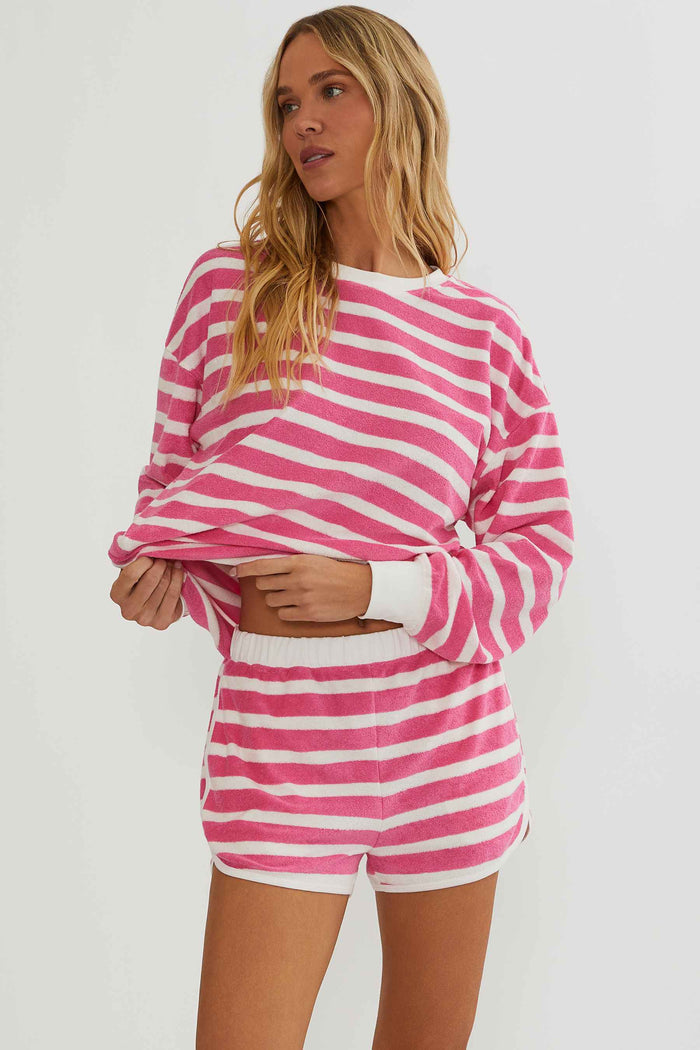 Woman wearing a pink and white striped outfit on a plain background