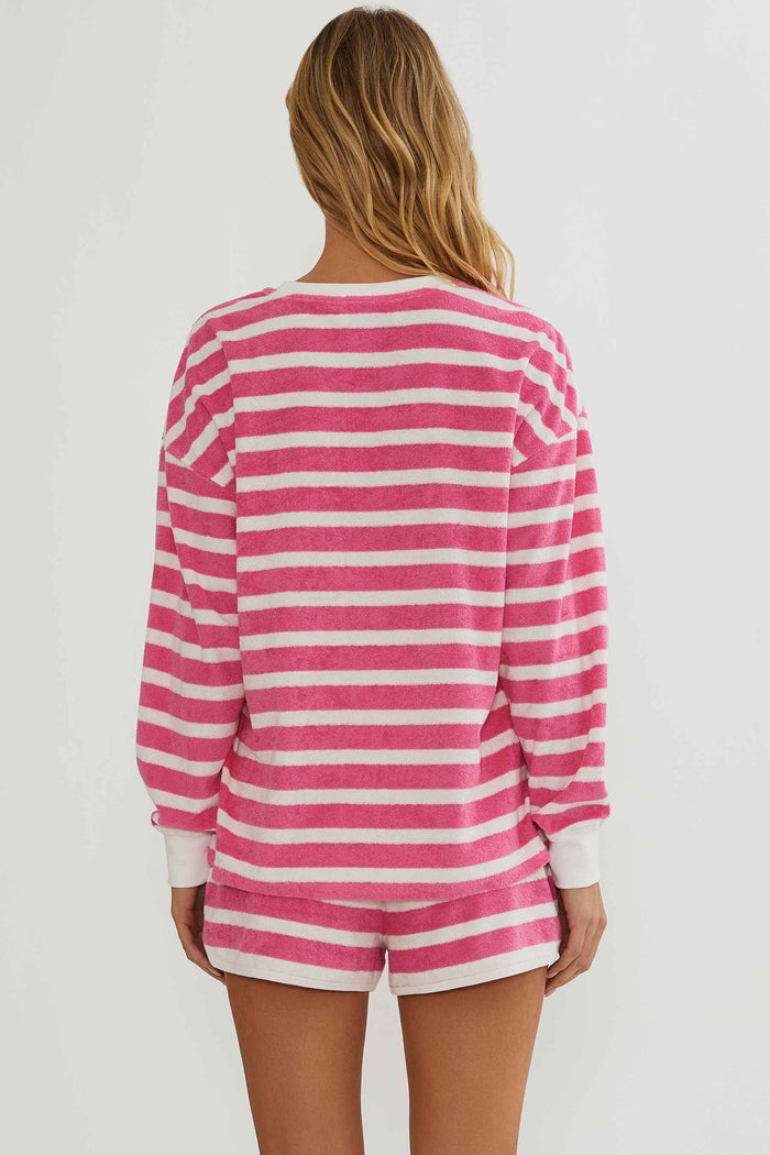 Person wearing a pink and white striped long-sleeve top and shorts on a plain background
