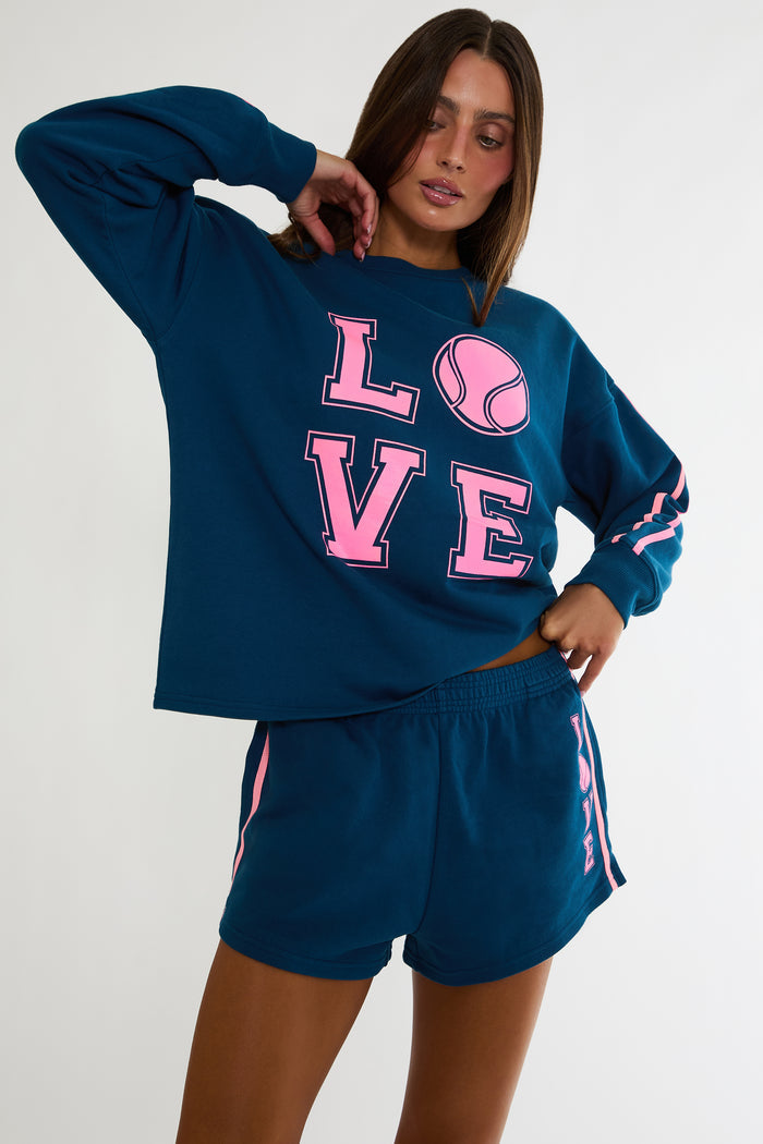 Navy sweatshirt with "Love" tennis text in pink.