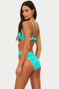 Woman wearing a turquoise bikini set on a white background