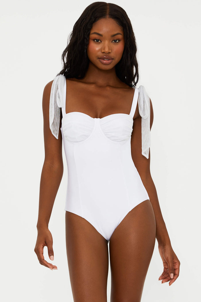 A white one-piece swimsuit with delicate straps that tie at the shoulders and ruched underwire cups with metallic threading.
