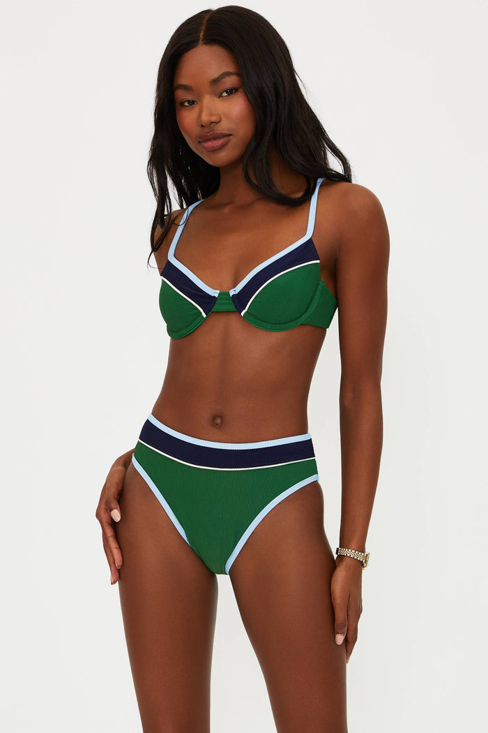 Woman wearing a green and navy bikini against a white background