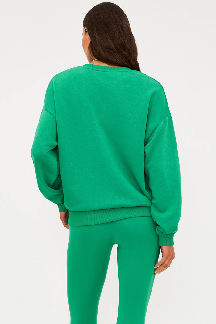 Person wearing a green sweatshirt and pants on a white background