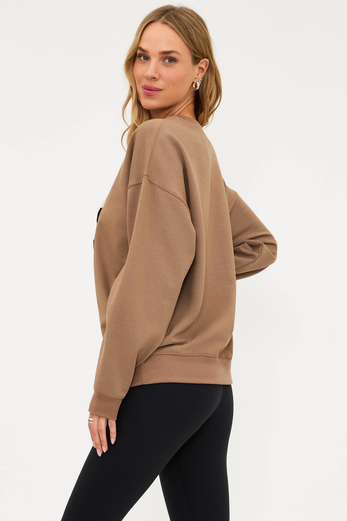 Woman wearing a beige sweatshirt with 'SPOOKY' text on a white background
