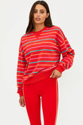 Woman wearing a red striped sweater and red pants on a white background
