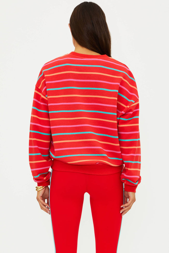 Person wearing a red and blue striped sweater with red pants on a white background