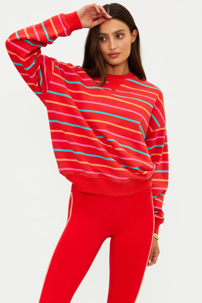 Person wearing a red striped sweater and red pants on a light gray background