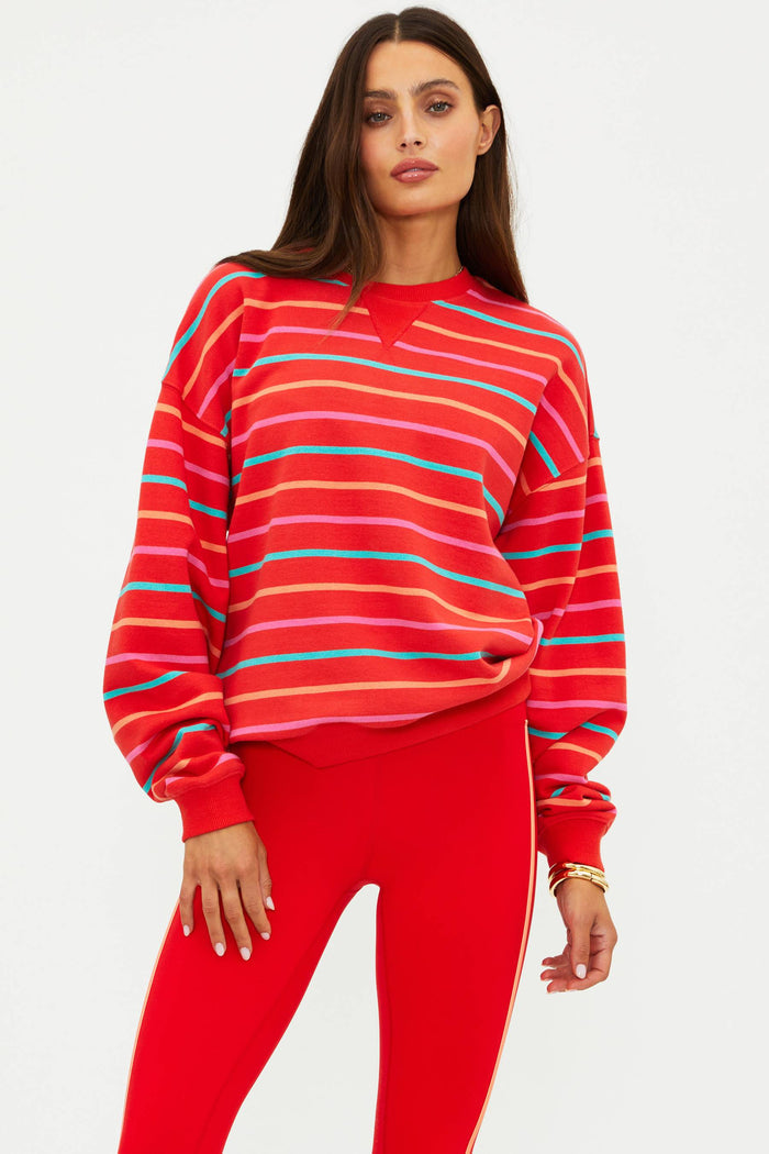 Woman wearing a red striped sweater and red pants on a white background