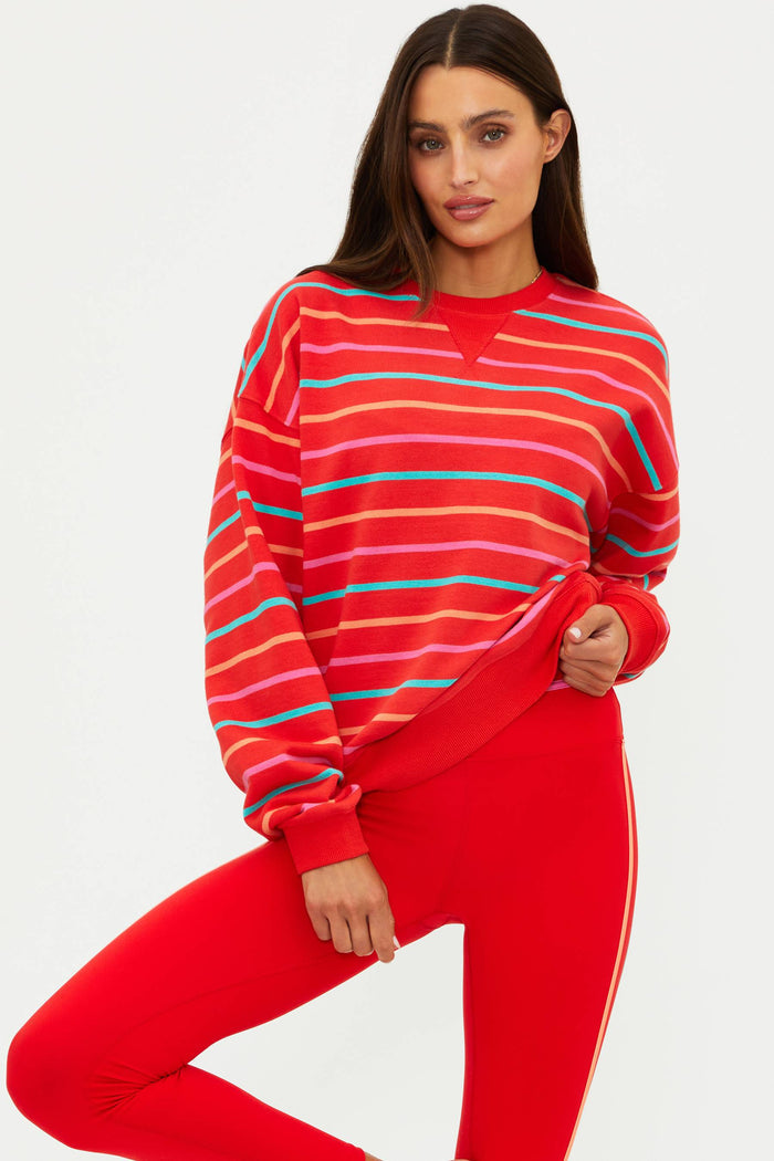 Woman wearing a red striped sweater and red pants on a white background