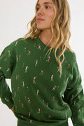 Woman wearing a green sweater with golf pattern on a white background