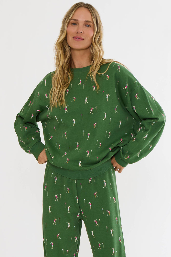Woman wearing a green patterned sweater and pants on a white background