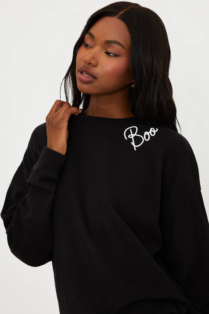 Person wearing a black outfit with white branding on a white background
