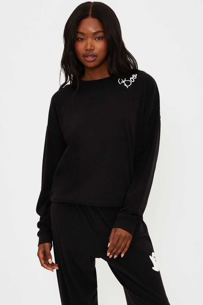 Person wearing a black outfit with white branding on a white background
