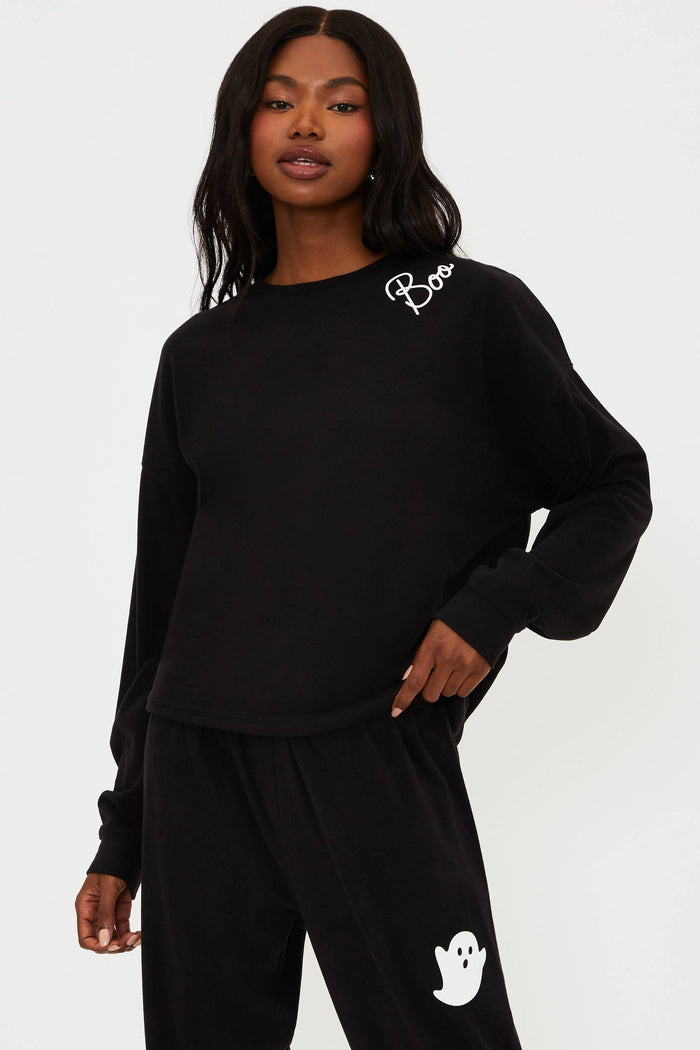 Person wearing a black outfit with white branding on a white background