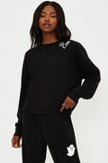 Person wearing a black outfit with white branding on a white background