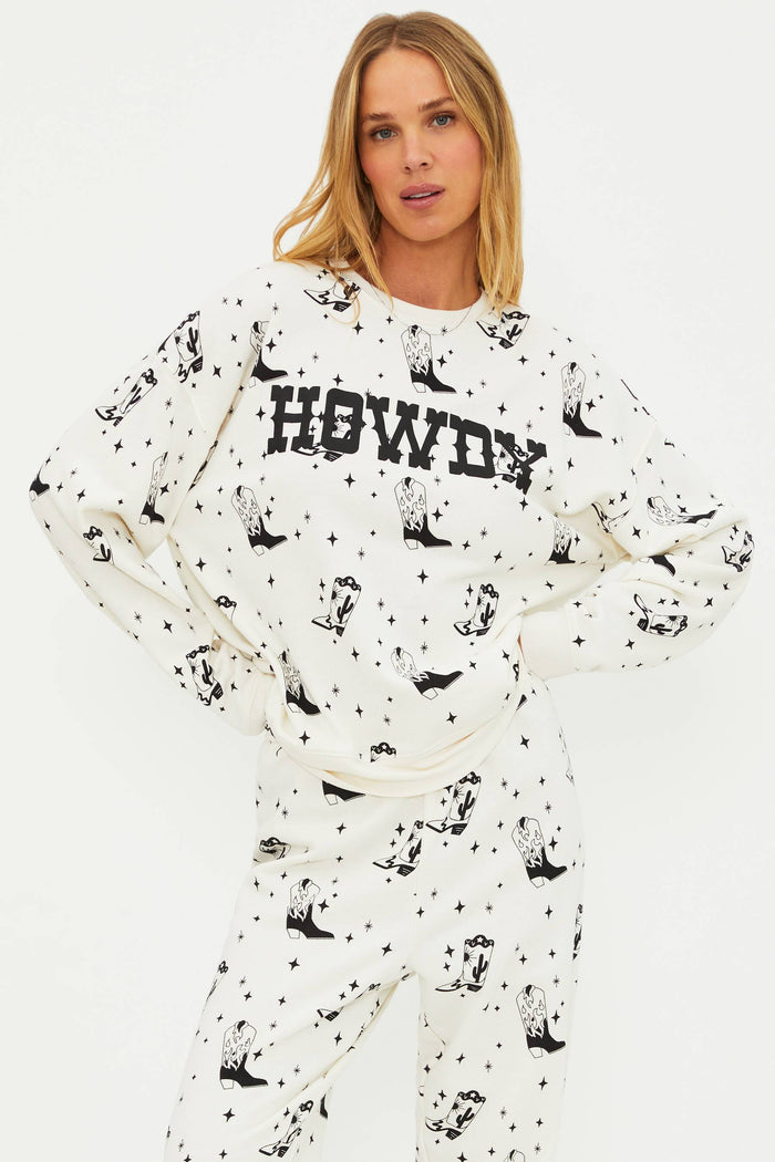 Woman wearing a white sweatshirt with black patterns and 'HOWDY' text on a white background