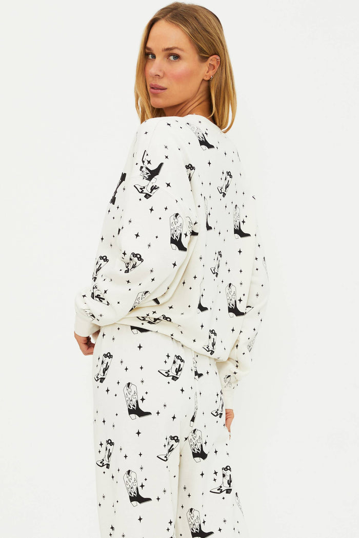 Woman wearing a white pajama set with black animal prints on a white background