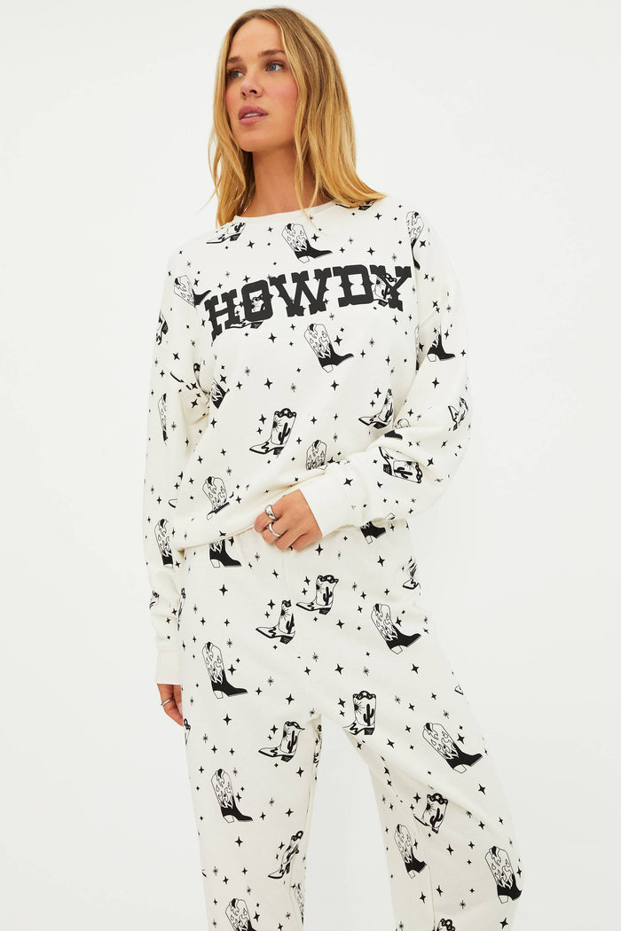 Person wearing a white pajama set with black text and animal prints on a plain background