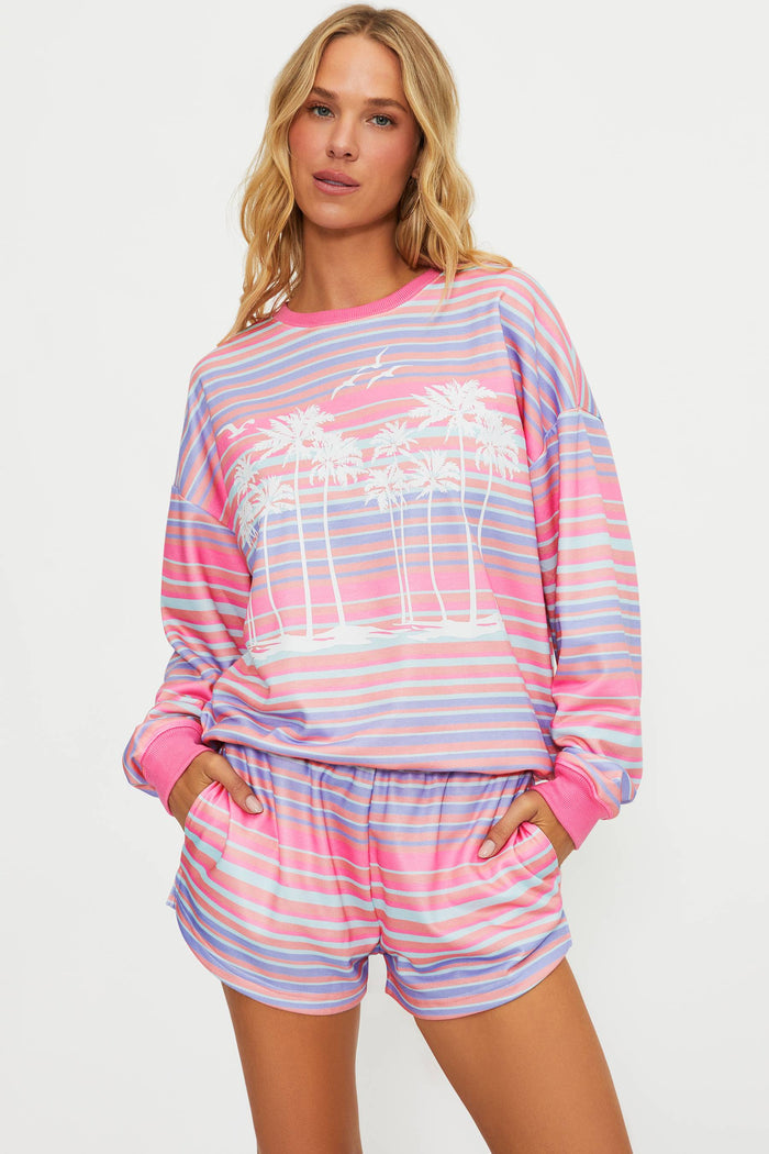 Woman wearing a colorful striped pajama set on a white background