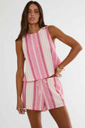 Woman wearing a pink and white striped sleeveless top and shorts set on a white background