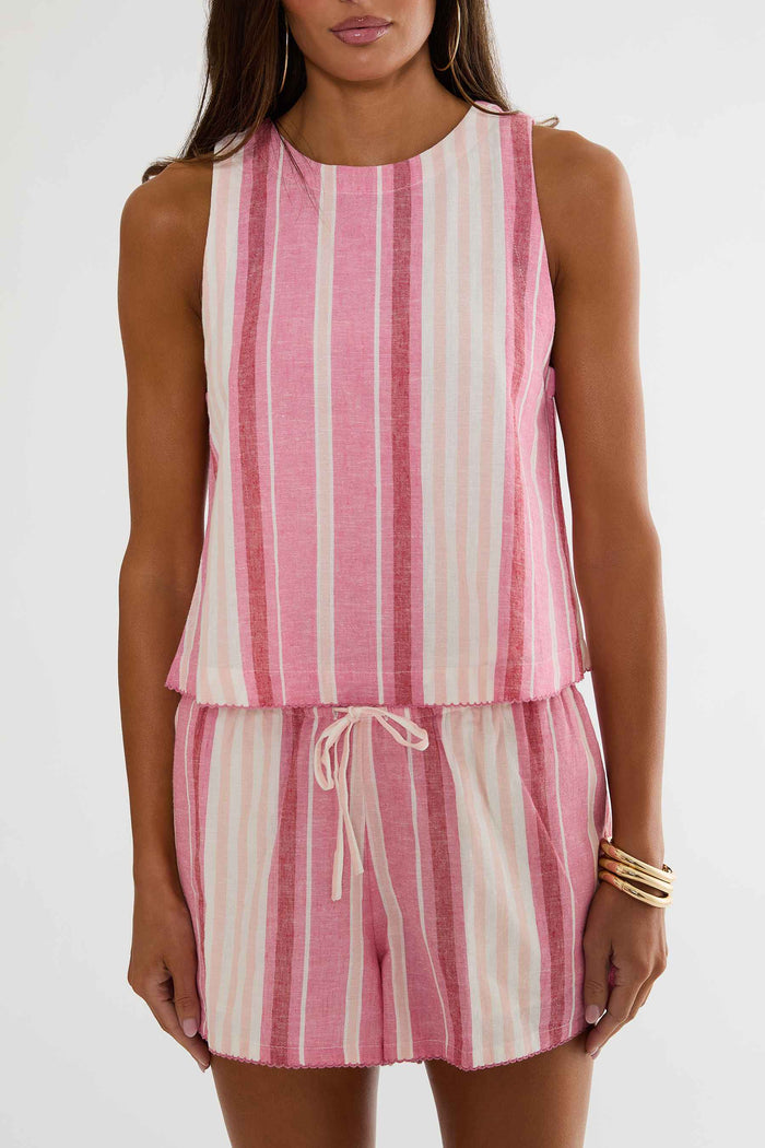 Woman wearing a pink and white striped sleeveless top and shorts set on a white background