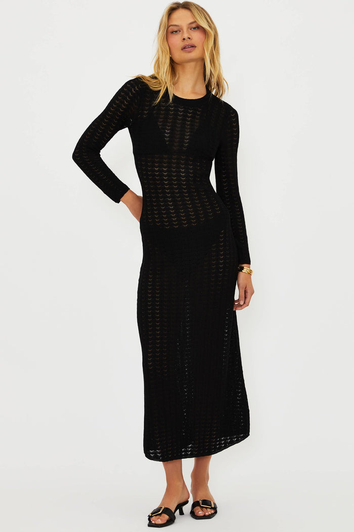 Woman wearing a black dress with a textured pattern on a white background