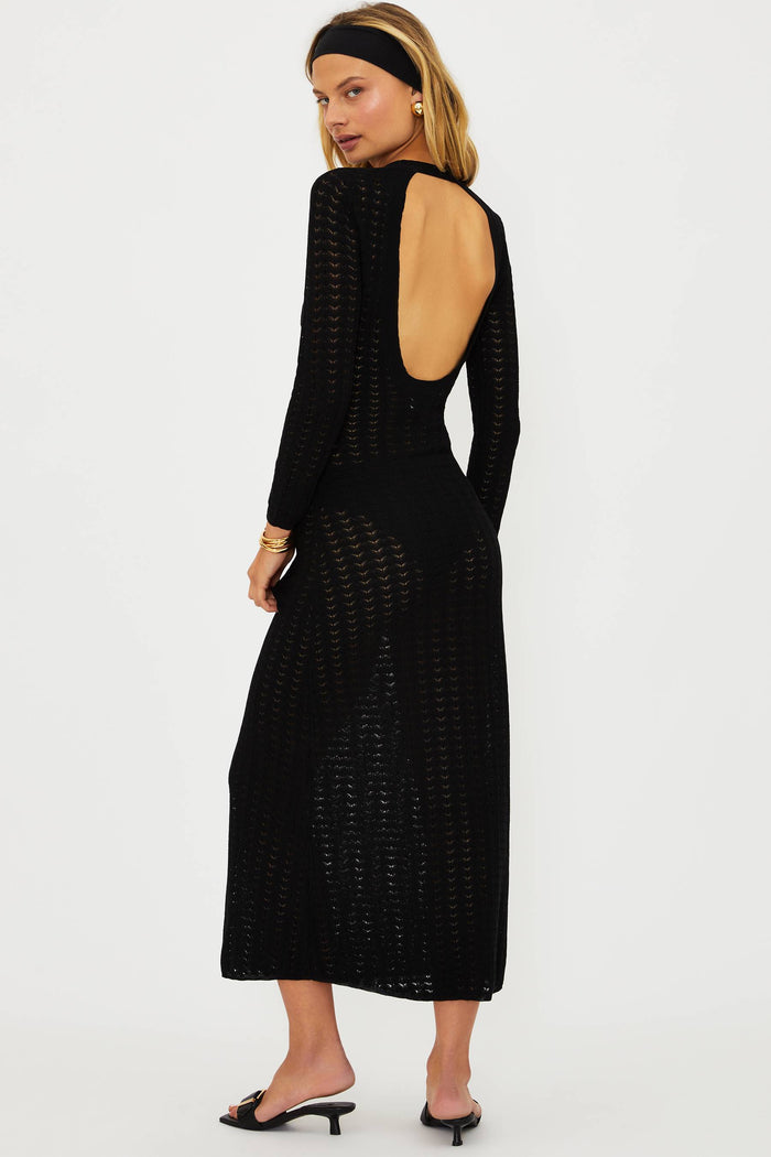 Woman wearing a black dress with cut-out design on a white background