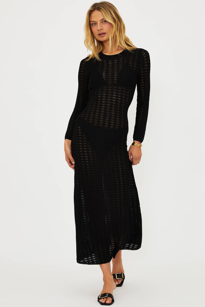 Woman wearing a black dress with a subtle pattern on a white background