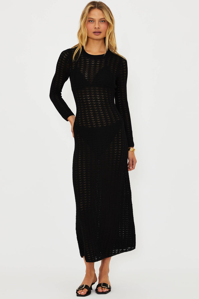 Woman wearing a black dress with a textured pattern on a white background