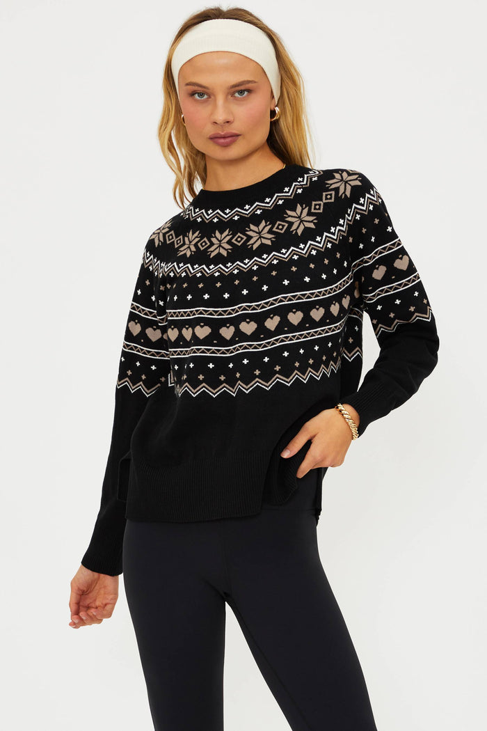 Woman wearing a black sweater with a pattern on a white background