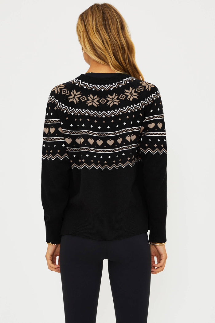 Woman wearing a black sweater with a pattern on a white background