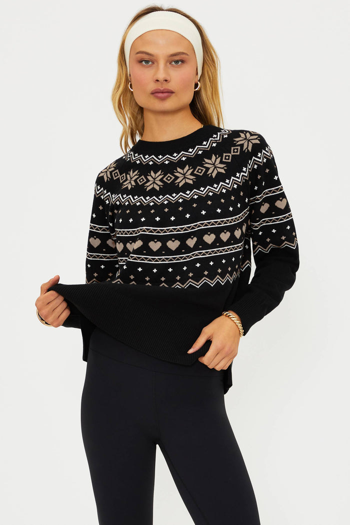 Woman wearing a black sweater with a pattern on a white background