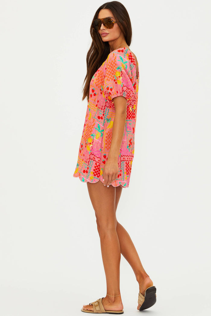 Woman wearing a colorful floral dress on a white background