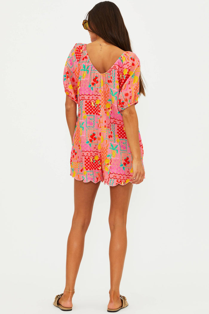 Woman wearing a colorful patterned dress on a white background