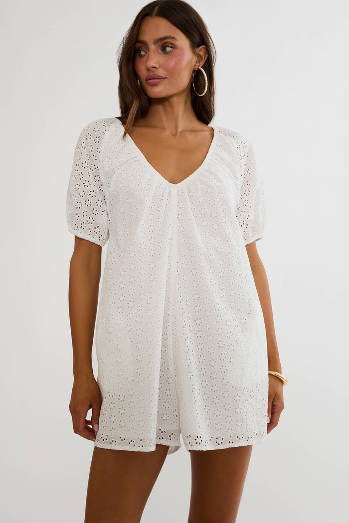 Woman wearing a white lace dress on a plain background