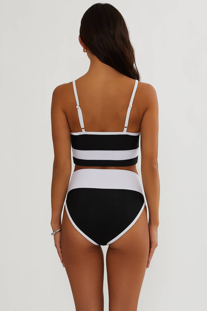 Black and white striped bikini worn by a model on a plain background