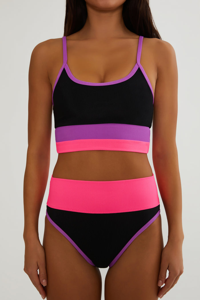 Black and pink bikini set with purple accents on a plain background