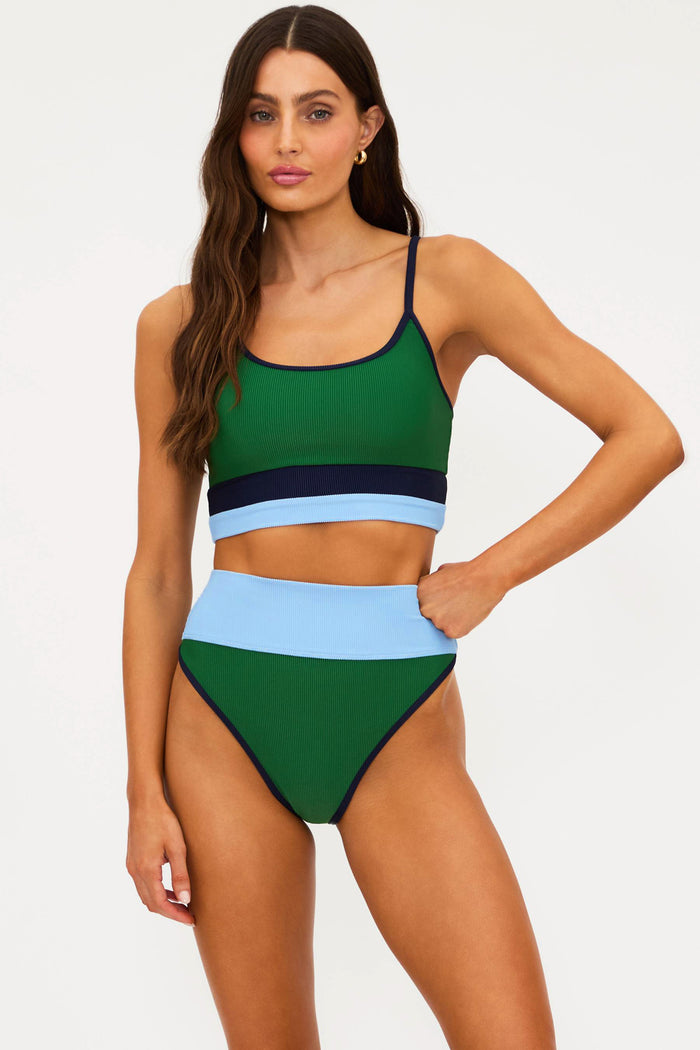 Woman wearing a green and blue bikini set on a white background